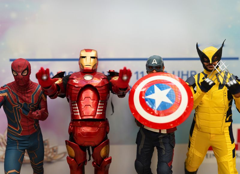 Vier als Superhelden verkleidete Darsteller stehen nebeneinander.